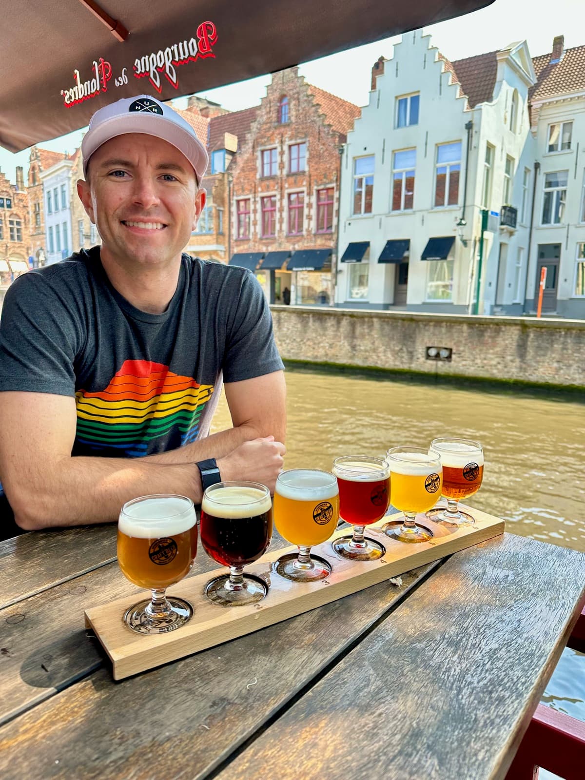 Brett with a beer flight on a canal terrace in Bruges