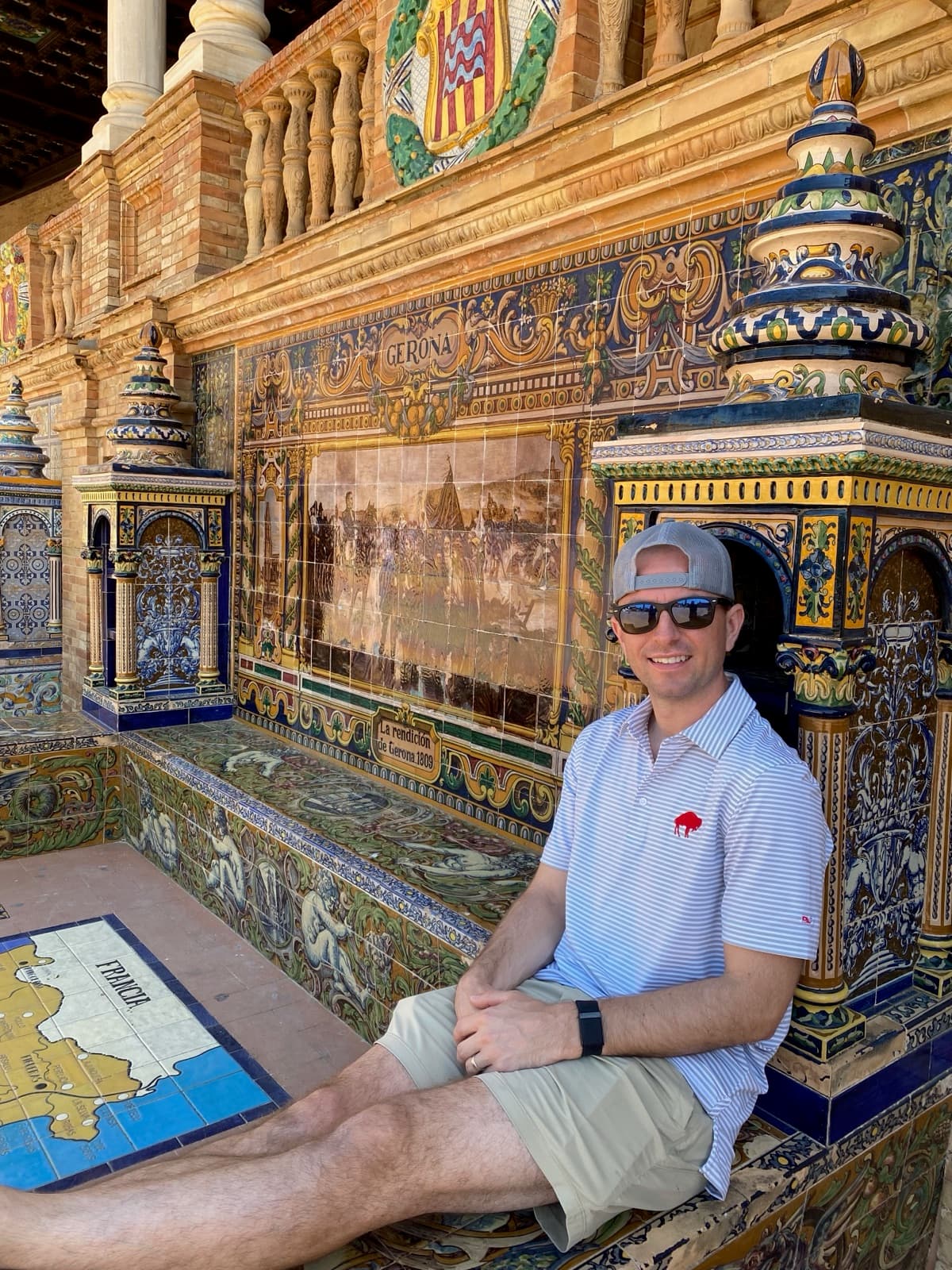Brett seated in a tiled alcove at Plaza de España in Seville